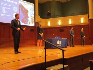 Four people on stage presenting their business plan